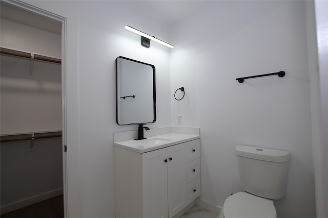 2427 Costa Mesa Dr, Dallas, TX 75228 - bathroom featuring baseboards, vanity, a walk in closet, and toilet