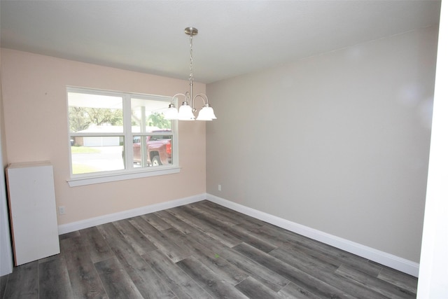 unfurnished room with baseboards, dark wood-style floors, and a chandelier
