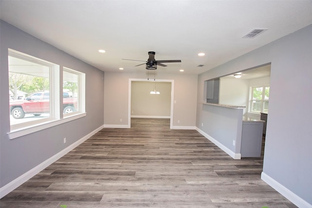 unfurnished room featuring recessed lighting, wood finished floors, a ceiling fan, and baseboards