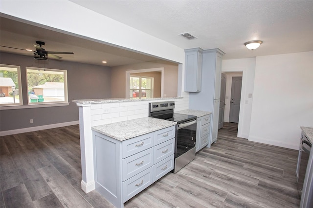 kitchen featuring stainless steel appliances, baseboards, visible vents, and a wealth of natural light