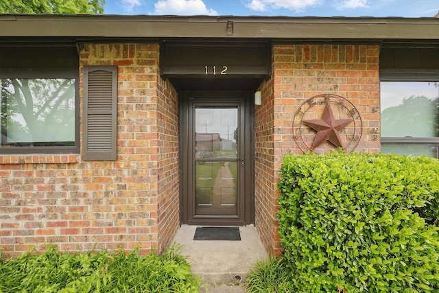 entrance to property featuring brick siding