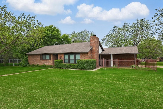 ranch-style home with fence, a chimney, brick siding, and a front yard