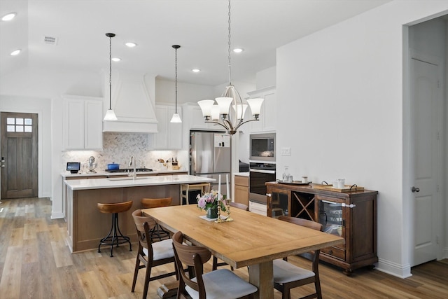 dining space with light wood-style flooring, visible vents, an inviting chandelier, recessed lighting, and baseboards