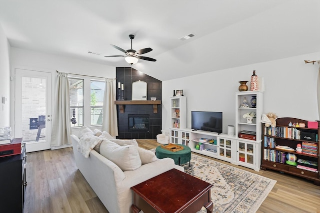 living area with vaulted ceiling, visible vents, wood finished floors, and ceiling fan