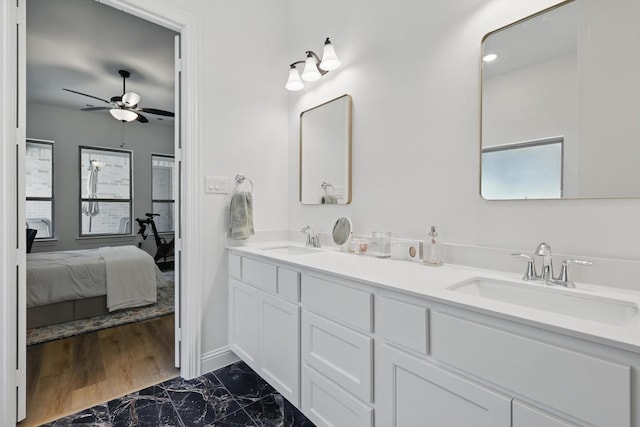 ensuite bathroom with ensuite bath, a healthy amount of sunlight, and a sink