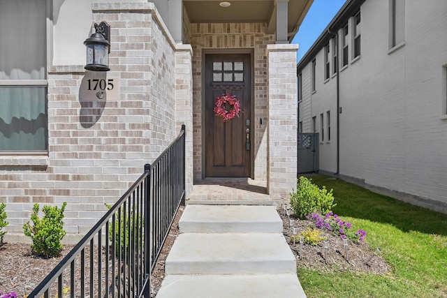 entrance to property featuring brick siding