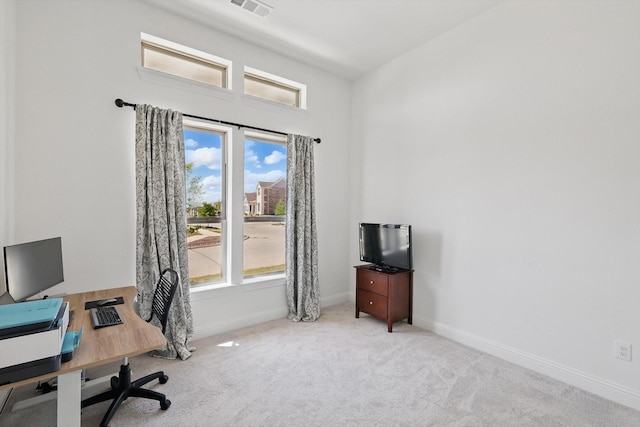 office area featuring carpet floors, a wealth of natural light, baseboards, and visible vents