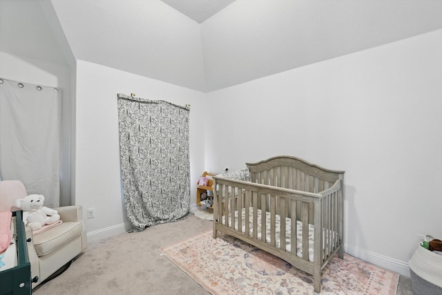 carpeted bedroom with a nursery area and baseboards