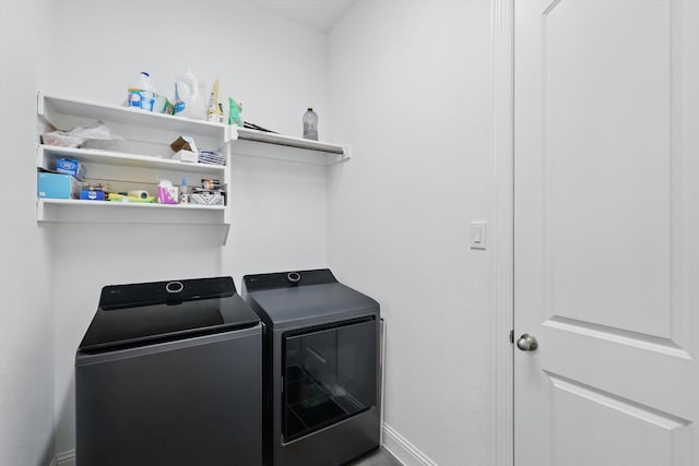 laundry area featuring separate washer and dryer, baseboards, and laundry area