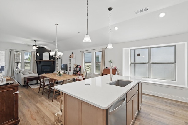 kitchen with light countertops, visible vents, stainless steel dishwasher, a sink, and light wood-type flooring