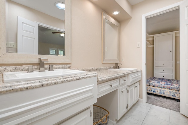 bathroom featuring ceiling fan, marble finish floor, a sink, and double vanity
