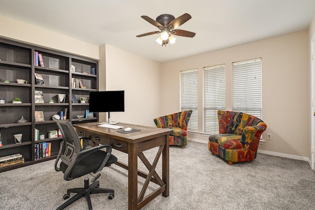home office featuring a ceiling fan, baseboards, and light colored carpet