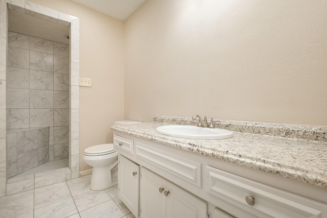 full bathroom with vanity, marble finish floor, tiled shower, and toilet