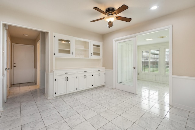 spare room with wainscoting and ceiling fan