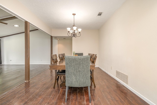 dining area featuring dark wood-type flooring, visible vents, and a notable chandelier