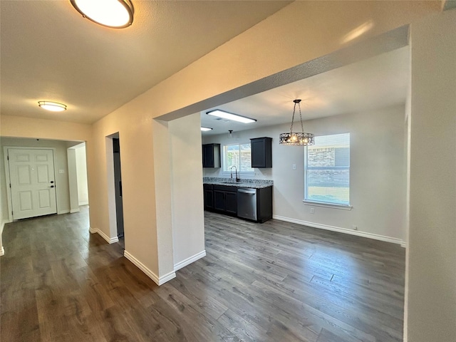 kitchen with stainless steel dishwasher, dark wood-style floors, a sink, a chandelier, and light countertops
