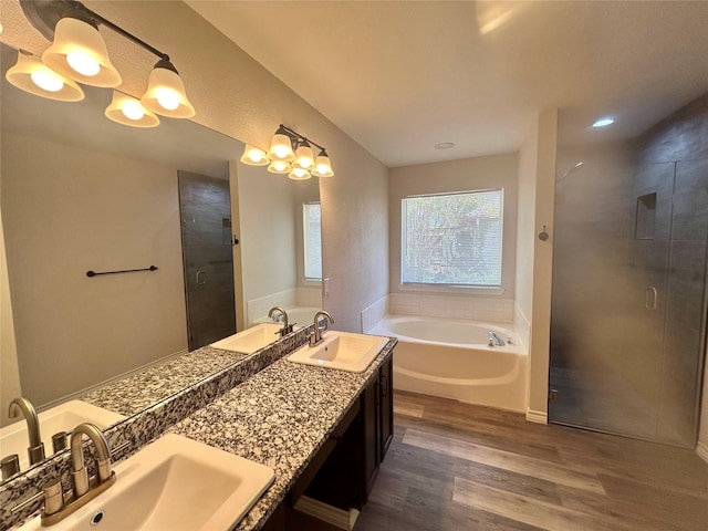 full bathroom featuring a garden tub, wood finished floors, a sink, and a stall shower