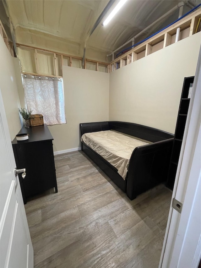 bedroom with baseboards and light wood-type flooring