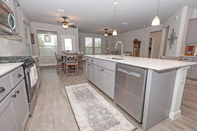 4125 Stockman Dr, Krum, TX 76249 - kitchen featuring appliances with stainless steel finishes, a sink, ceiling fan, and gray cabinetry