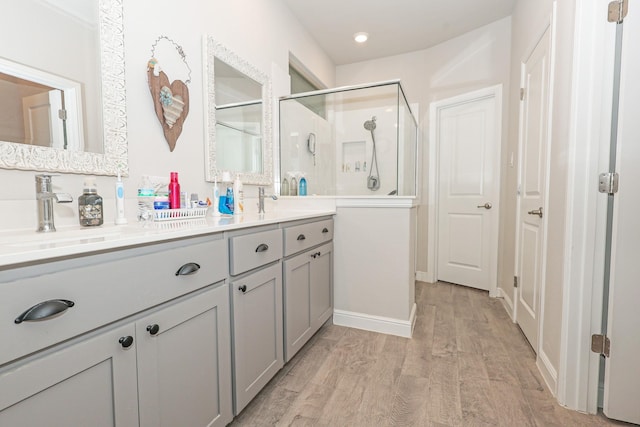 4125 Stockman Dr, Krum, TX 76249 - bathroom with wood finished floors, double vanity, a stall shower, and baseboards
