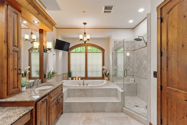 bathroom with a garden tub, tile patterned flooring, an inviting chandelier, vanity, and a stall shower