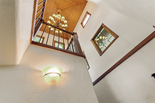 stairs featuring a high ceiling and a chandelier