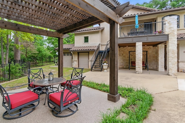 view of patio / terrace featuring fence, outdoor dining space, a pergola, stairway, and a balcony