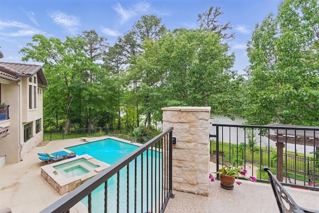 view of swimming pool with fence, a diving board, and a pool with connected hot tub