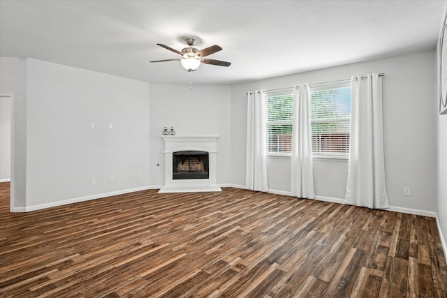 5208 Hidden Knolls Dr, Mckinney, TX 75071 - unfurnished living room featuring dark wood-style floors, a ceiling fan, a fireplace with raised hearth, and baseboards