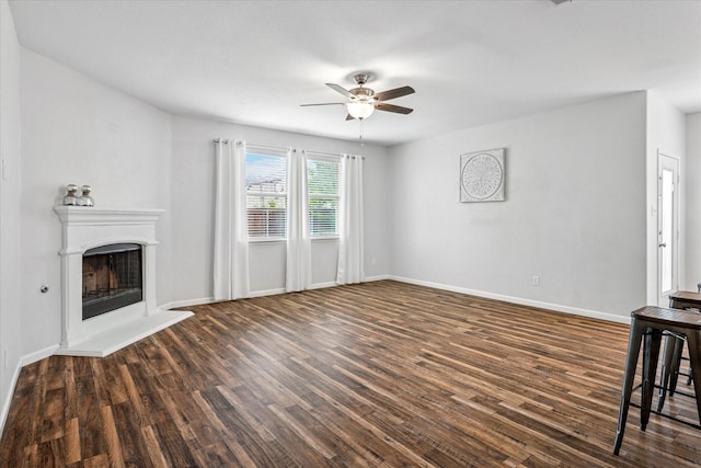 5208 Hidden Knolls Dr, Mckinney, TX 75071 - unfurnished living room with ceiling fan, dark wood-style floors, a fireplace with raised hearth, and baseboards