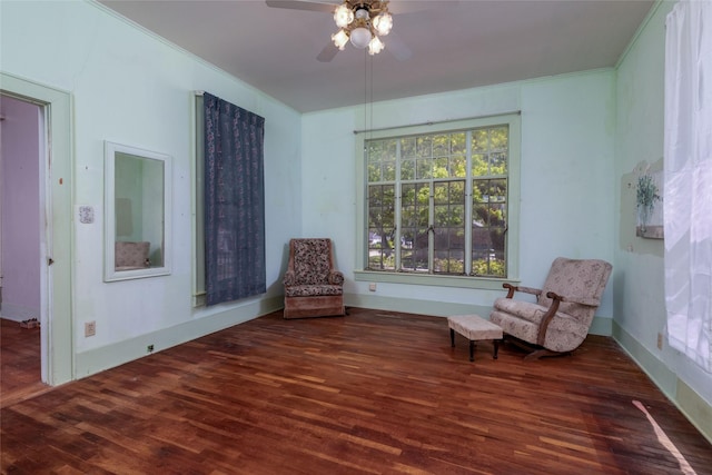 living area with wood finished floors, crown molding, and ceiling fan