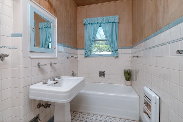bathroom with a washtub, heating unit, and tile walls