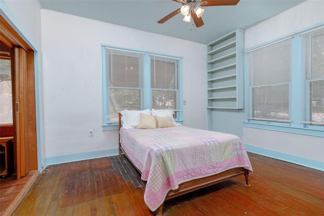 bedroom featuring hardwood / wood-style floors, a ceiling fan, and baseboards