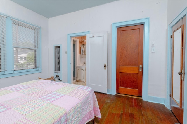 bedroom with baseboards, connected bathroom, and wood-type flooring
