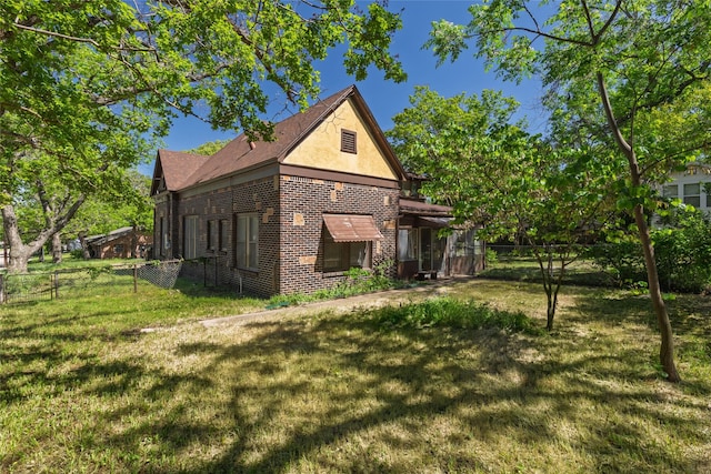 back of property with a fenced backyard, brick siding, a yard, and stucco siding
