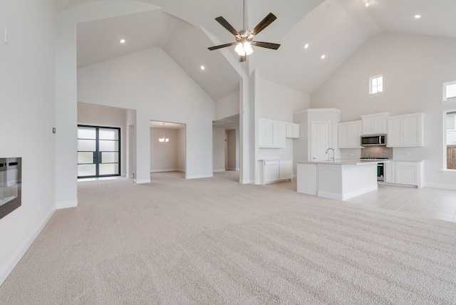 1006 Cascading Creek Dr, Rockwall, TX 75087 - unfurnished living room featuring high vaulted ceiling, a sink, light colored carpet, baseboards, and ceiling fan