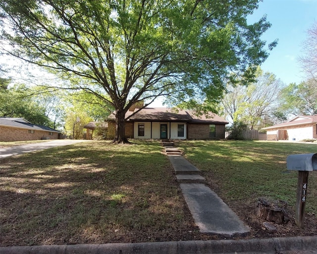 ranch-style home featuring a front lawn and fence