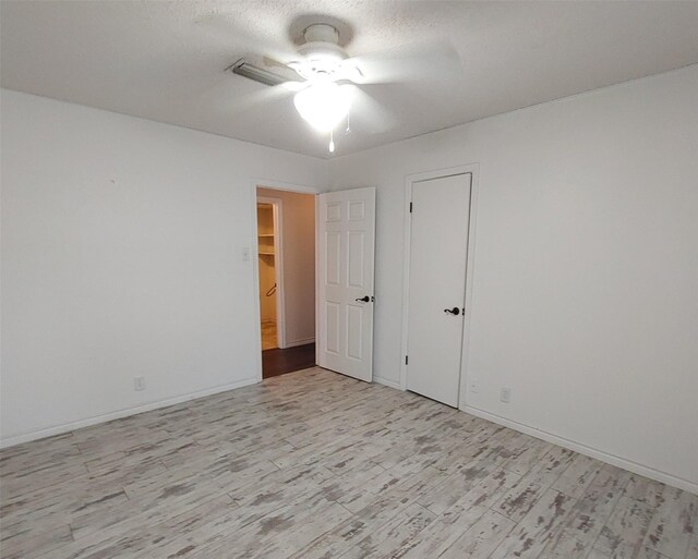 interior space with light wood finished floors, a ceiling fan, and baseboards