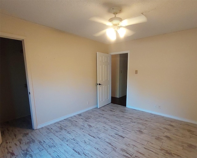 interior space featuring baseboards, a ceiling fan, and wood finished floors