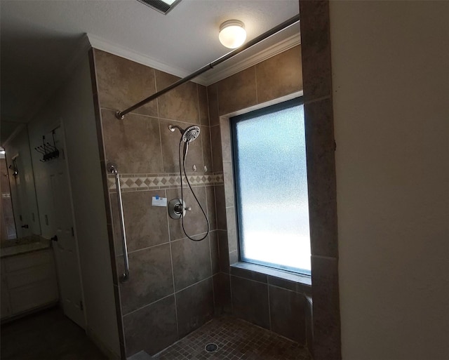full bath featuring visible vents, a tile shower, and crown molding