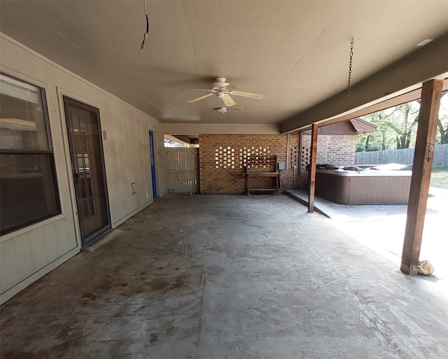 view of patio / terrace featuring a ceiling fan, a hot tub, and fence