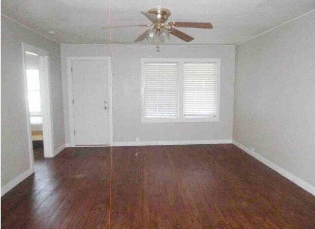 empty room featuring baseboards, a ceiling fan, and wood finished floors