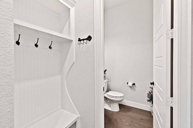 bathroom with wood finished floors, toilet, and baseboards
