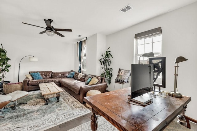 living room with a ceiling fan, wood finished floors, and visible vents