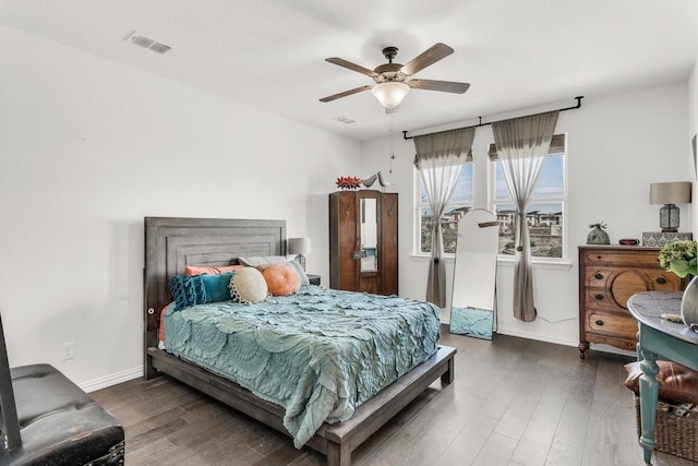 bedroom with wood finished floors, visible vents, baseboards, and ceiling fan