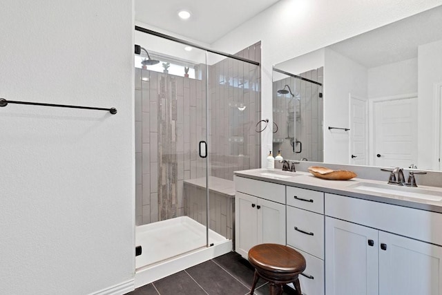 full bath with a shower stall, tile patterned flooring, a sink, and double vanity