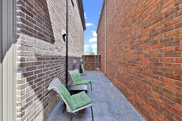 view of home's exterior with fence, a gate, and brick siding