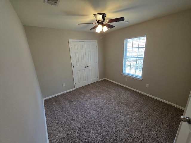 unfurnished bedroom featuring visible vents, a closet, baseboards, carpet, and a ceiling fan