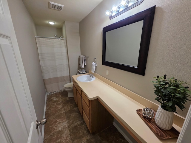 bathroom featuring stone finish flooring, a shower with shower curtain, toilet, vanity, and visible vents