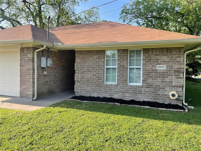 view of property exterior featuring roof with shingles, a yard, and an attached garage